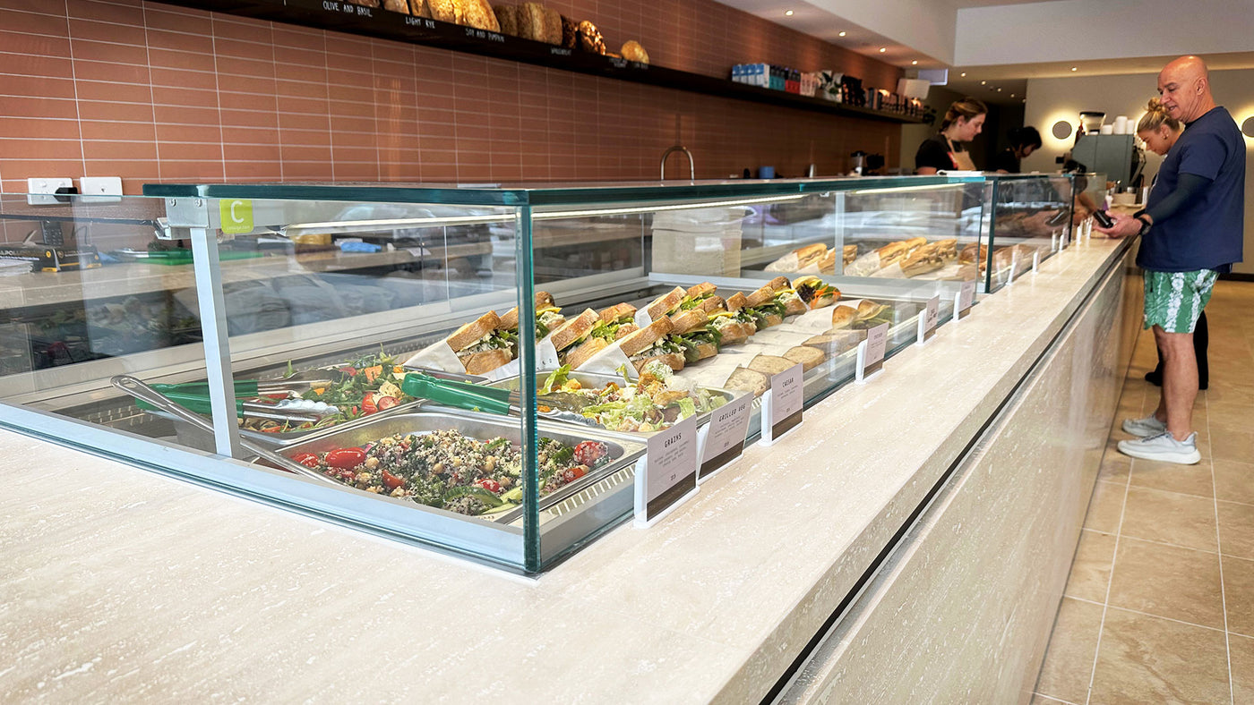 Self-service salad bar with various food options in a modern interior setting.